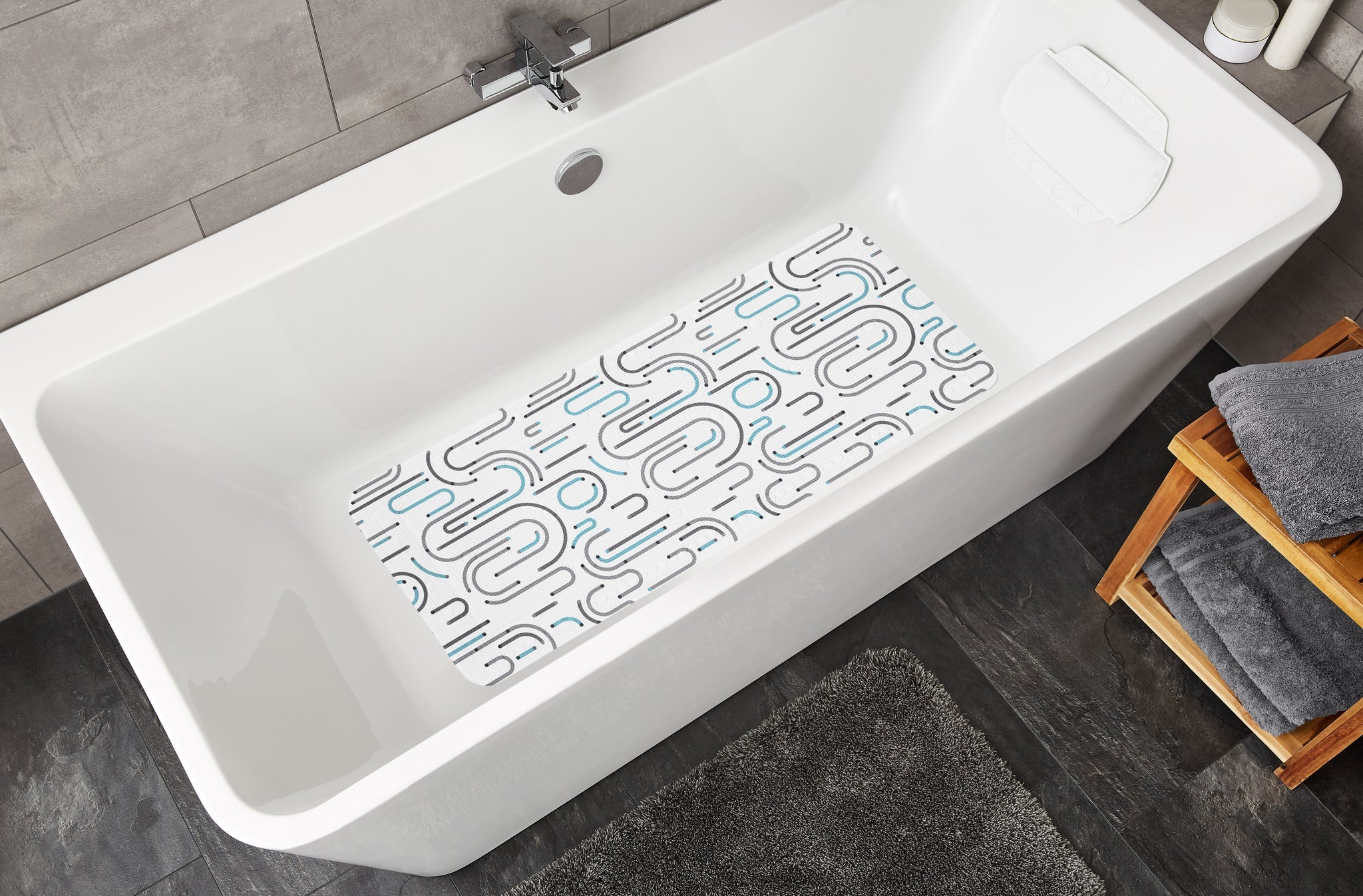 Weiße Badewanne mit rutschfester Badematte mit grauen und blauen Mustern