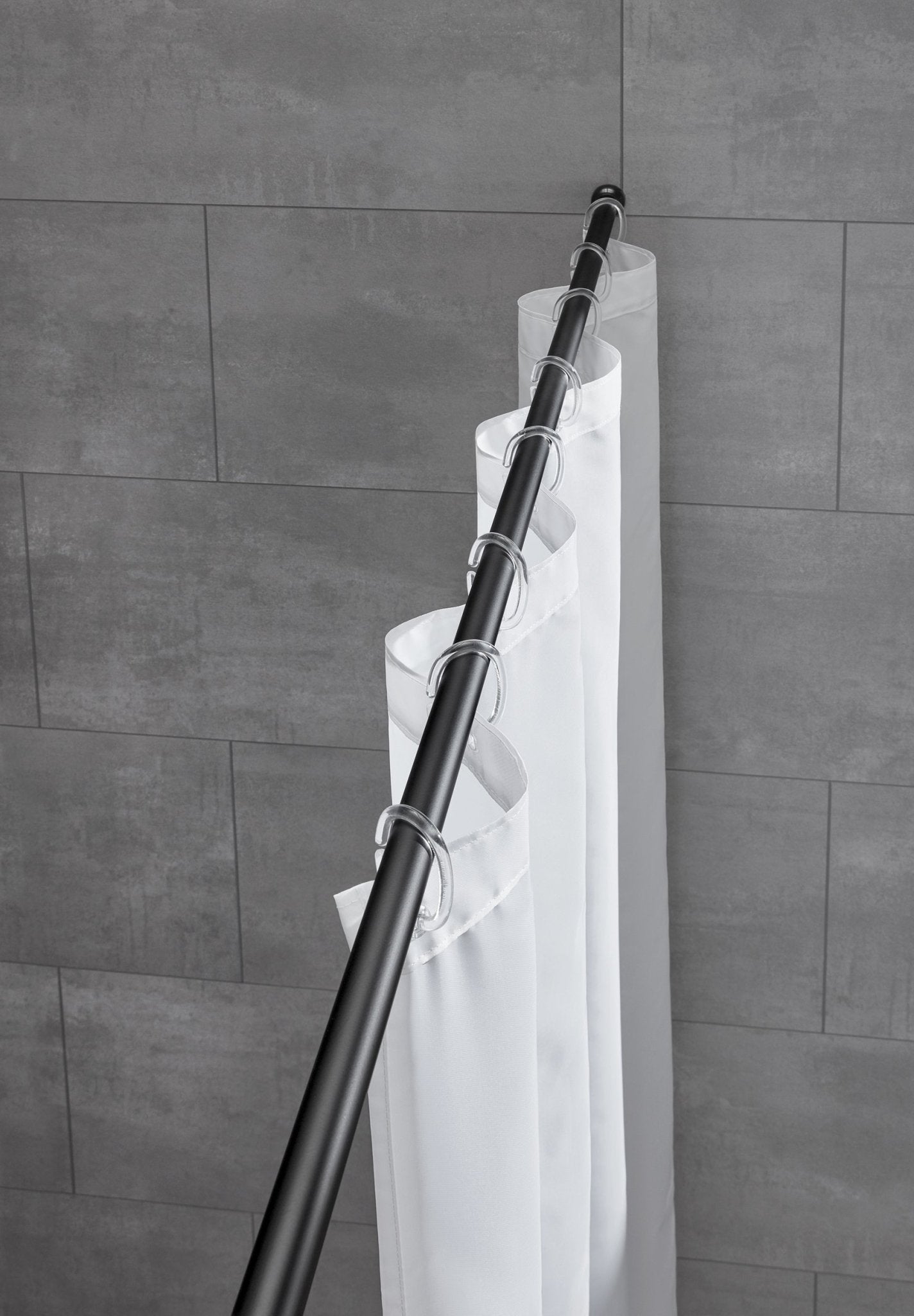 Schwarze Duschvorhang-Federstange mit weißem Vorhang vor grauer Badezimmerfliese ist montiert.