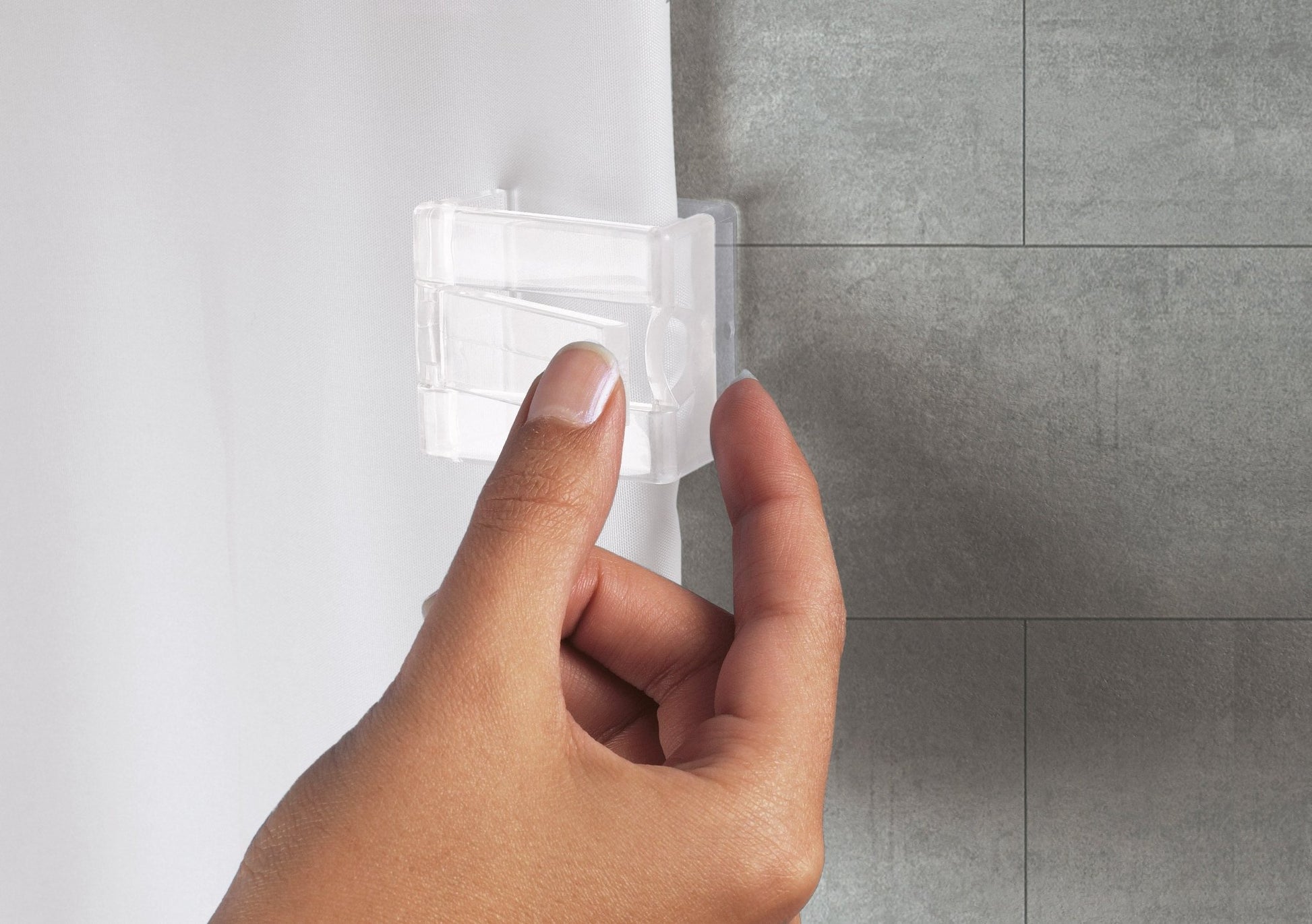 Hand befestigt transparente Duschvorhang-Klammer an weißem Vorhang