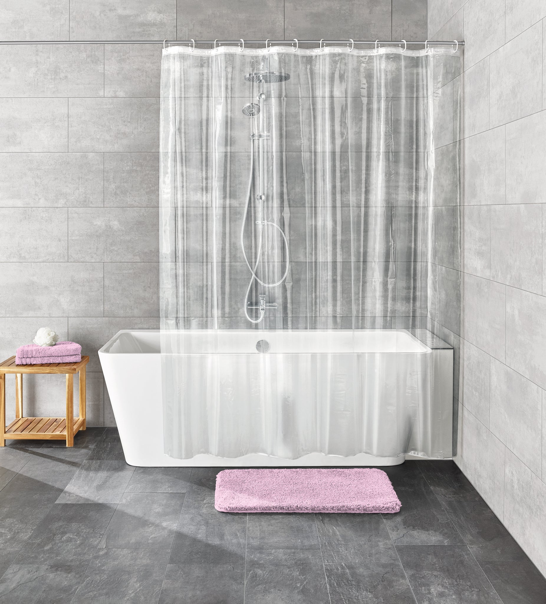 Transparenter Duschvorhang PEVA CLARO Clear 180 x 200 cm an Badewanne mit grauen Fliesen und rosa Badematte.