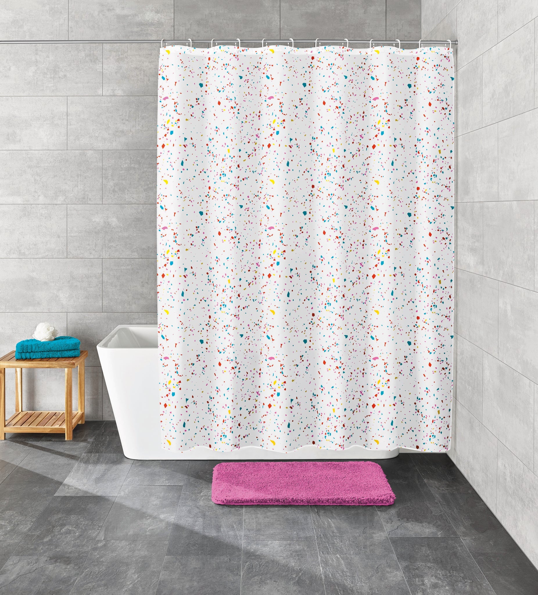 Bunter Duschvorhang mit Konfettimuster hängt vor einer Badewanne in einem modernen Badezimmer.