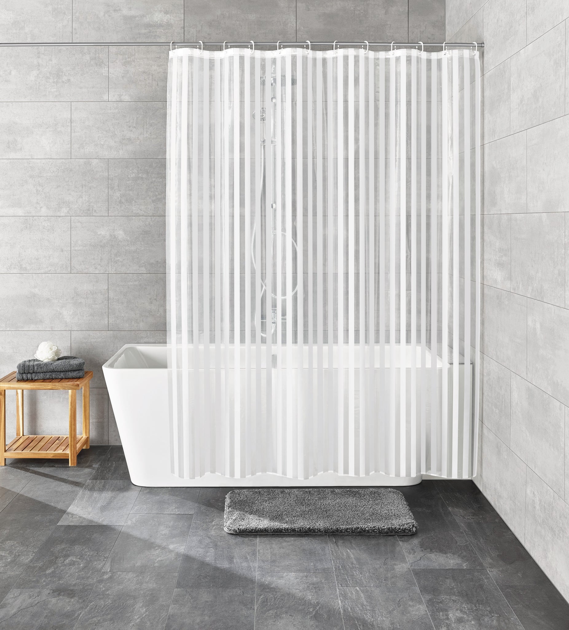 Weißer Duschvorhang PEVA NOA 180 x 200 cm hängt vor moderner Badewanne im grauen Badezimmer.