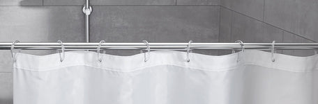 Weißer Duschvorhang an Metallstange vor grauen Badezimmerfliesen