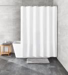 Weißer Duschvorhang vor Badewanne mit grauer Matte und Hocker aus Holz