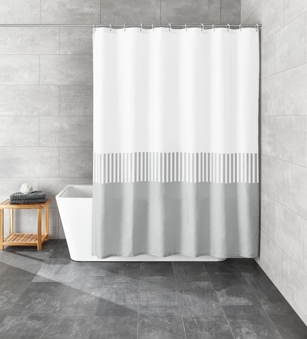 Weiß-grauer Duschvorhang in modernem Bad mit freistehender Wanne.