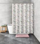 Graues Duschvorhang mit buntem Blumenmuster vor weißer Badewanne