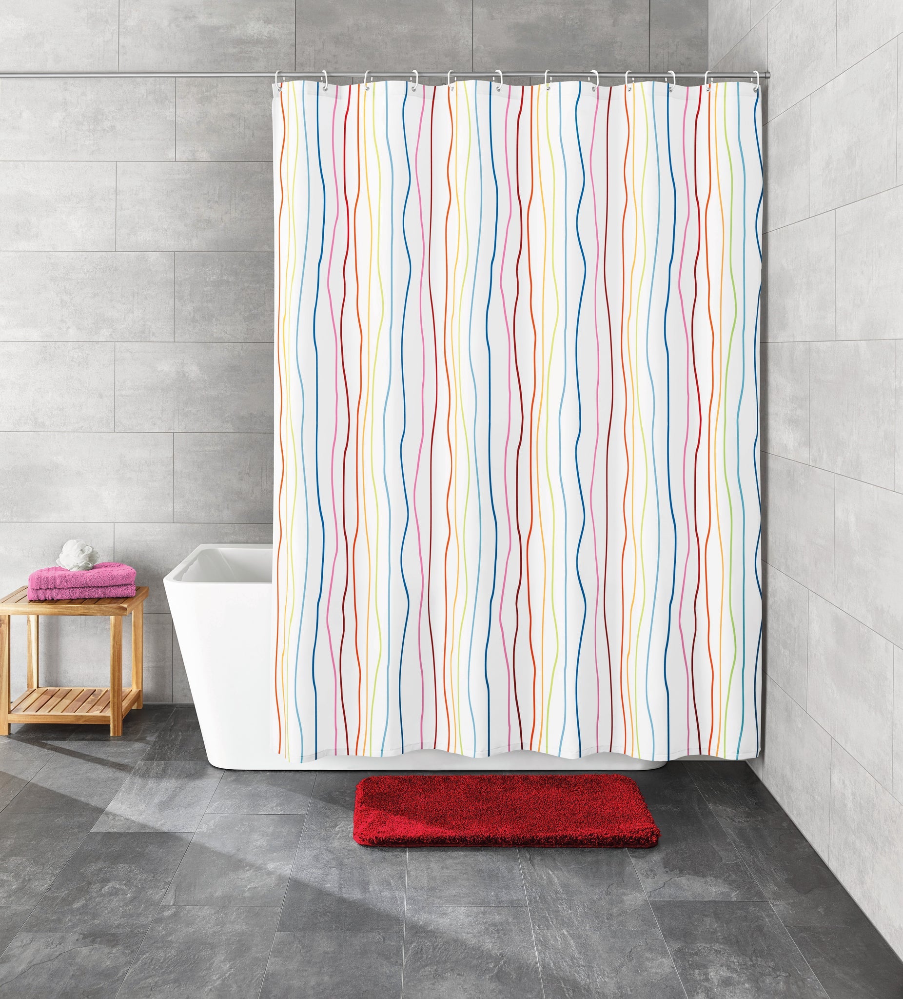 Modernes Badezimmer mit buntem Duschvorhang, roter Badematte und Badewanne