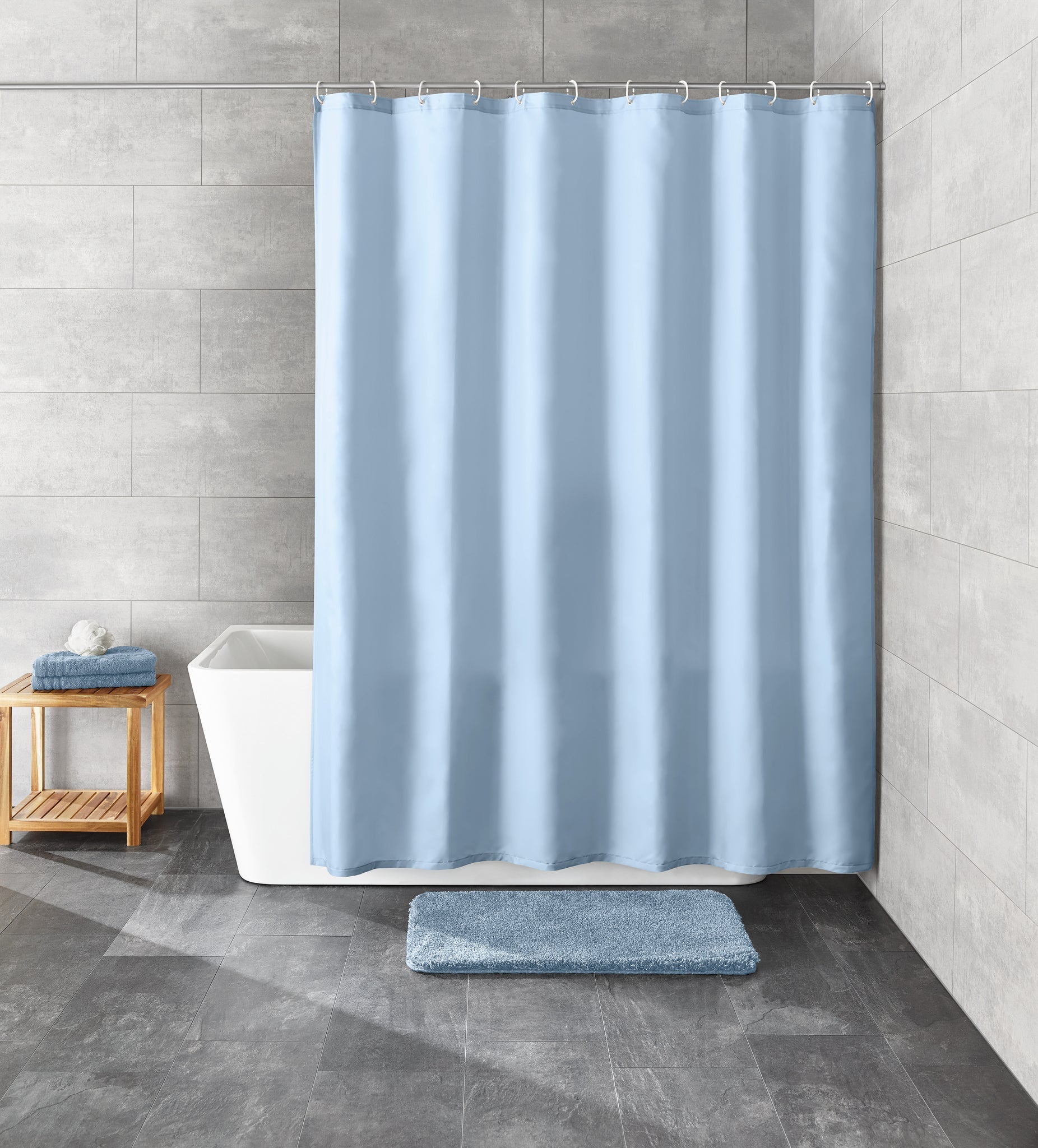 Der hellblaue Duschvorhang Textil KITO Azur 120 x 200 cm hängt vor einer weißen Badewanne.