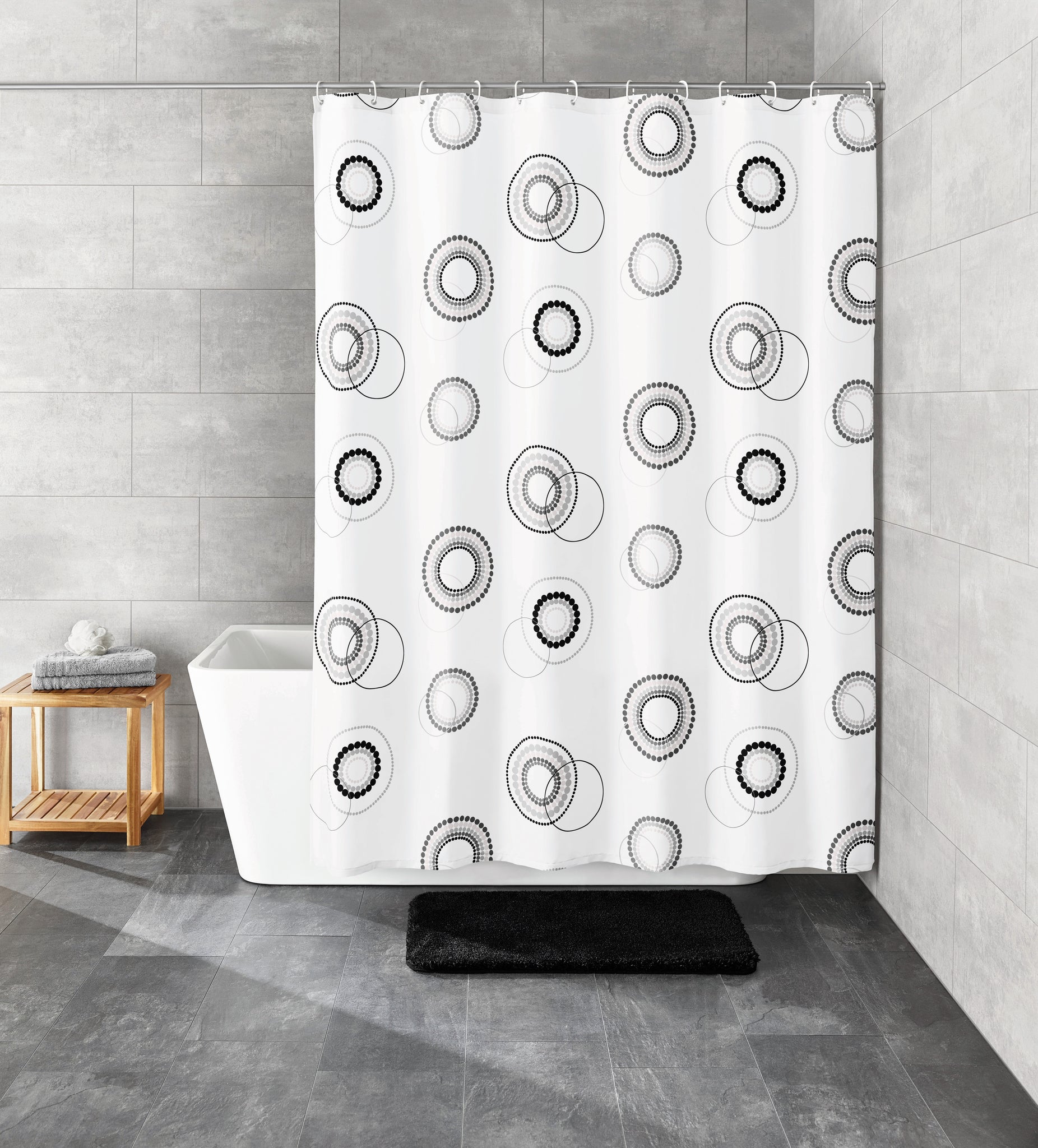 Duschvorhang Textil LUNA Schwarz-Weiß 180 x 200 cm vor Badewanne in modernem Bad mit grauen Fliesen.