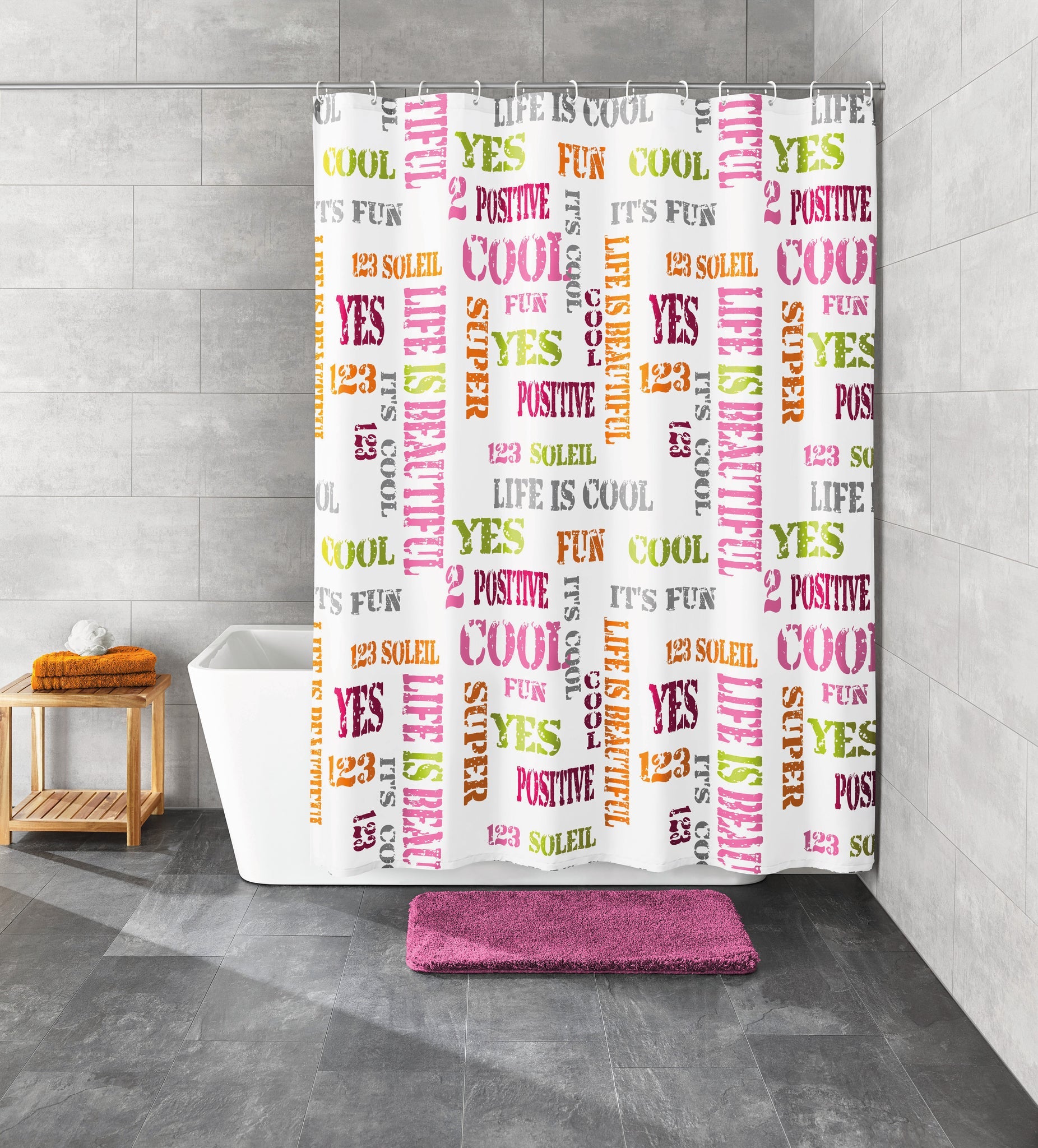Bad mit weißer Wanne, bunter Text-Duschvorhang und flauschiger lila Badematte