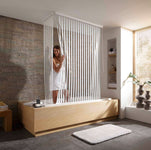 Badewanne mit Holzverkleidung, Duschvorhang und lächelnder Frau im Bad