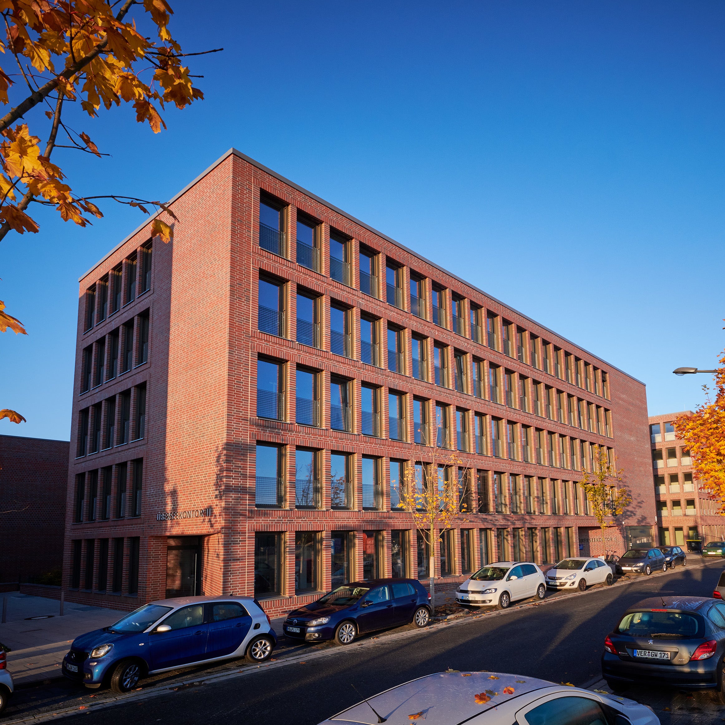 Das Foto zeigt das Kleine-Wolke-Firmengebäude 2025 mit Backsteinfassade in herbstlicher Straßenansicht.
