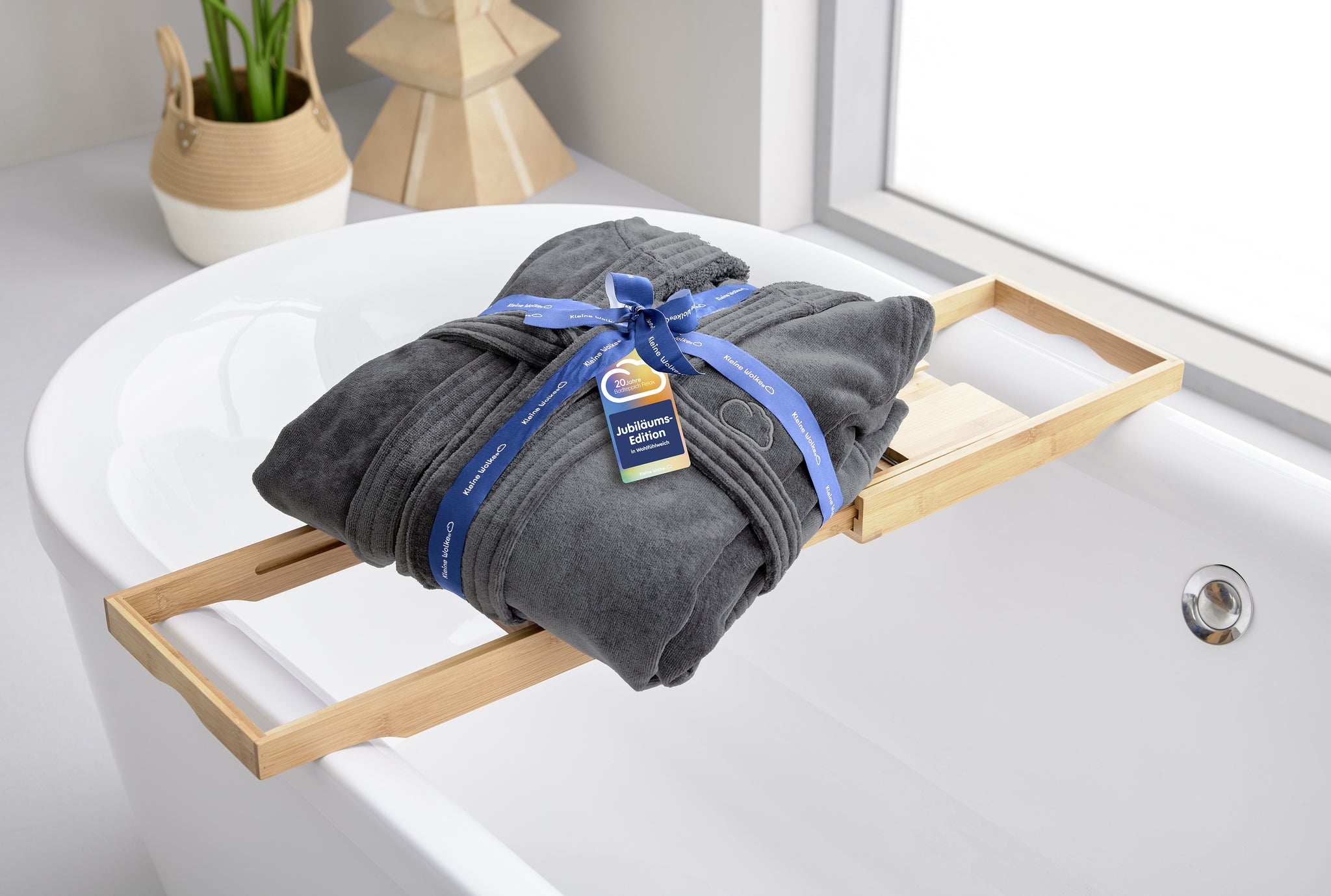 Dunkelgrauer Bademantel mit Schleife auf Bambus-Badewannenablage