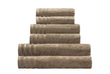 Gestapeltes Set aus fünf beigefarbenen Frotteehandtüchern, gerollt