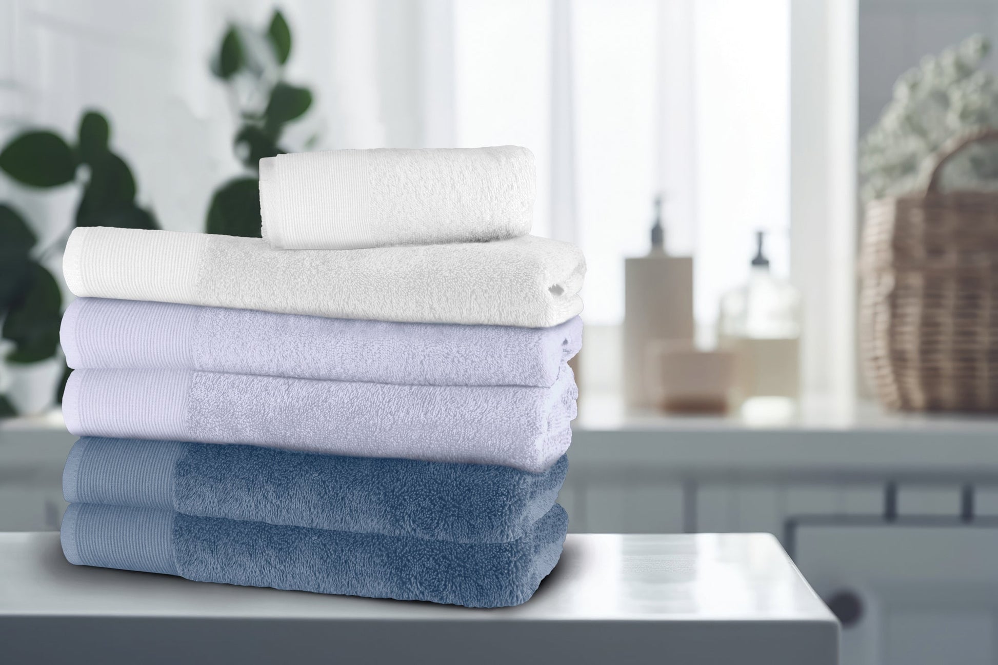 Gestapelte Badehandtücher in Blau, Lila und Weiß auf Badablage vorne