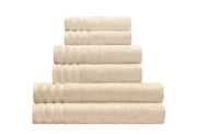 Frottier Gästetuch ROYAL sandbeige 30x50 cm liegt in einem Stapel gleichfarbiger Handtücher.