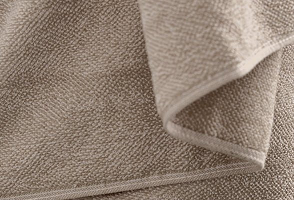 Detailansicht Frottier-Set CHILL Taupe mit gefalteten Handtüchern aus weichem Frottierstoff.
