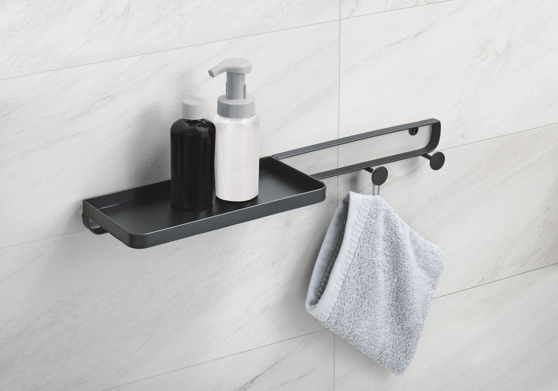 Schwarzes Wandregal mit Spenderflaschen und grauem Handtuch im Bad