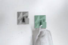 Zwei wandmontierte Handtuchhalter in Grau und Mint im modernen Bad