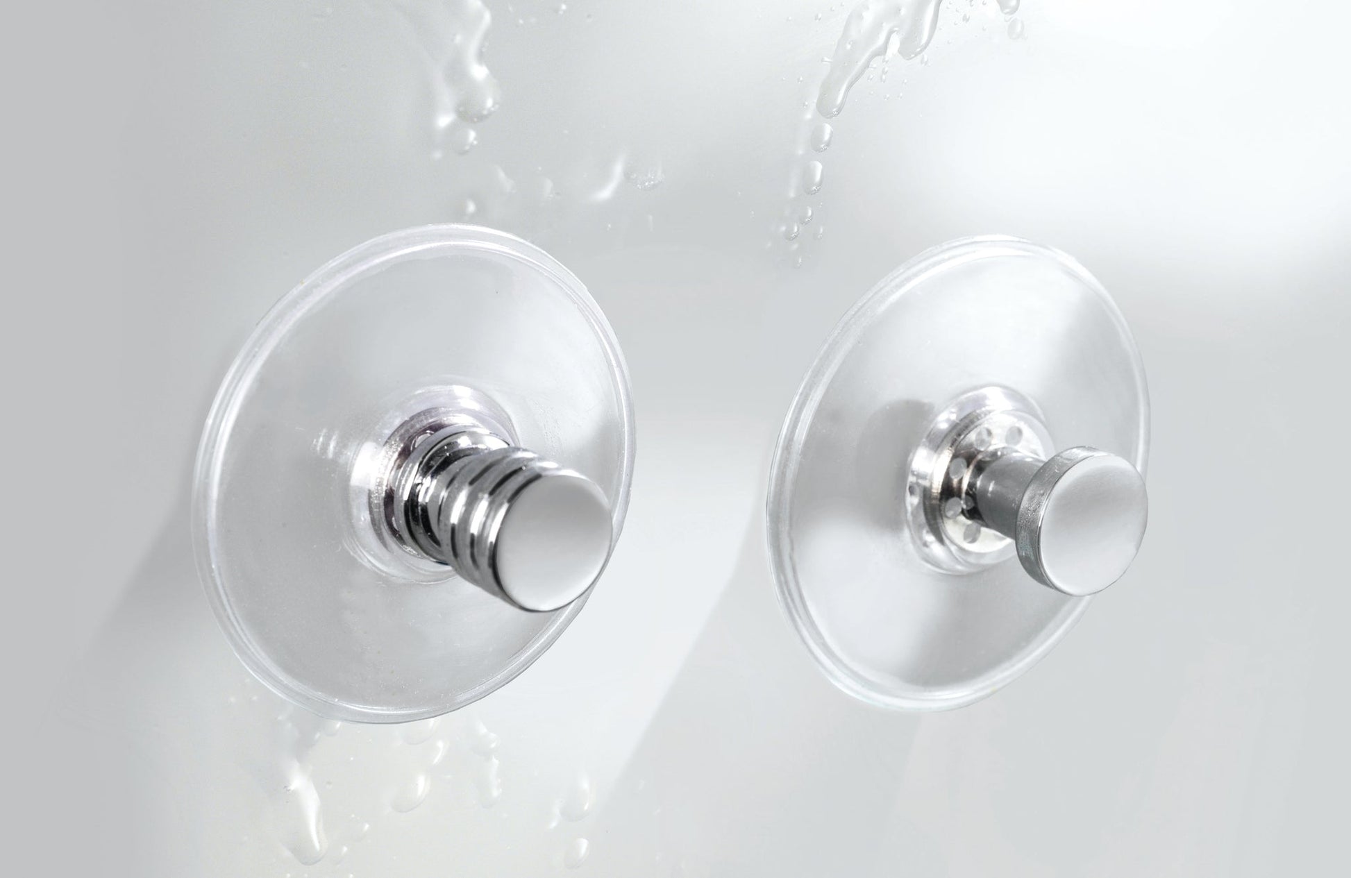 Zwei runde Chrom-Wandhaken mit transparenten Saugnäpfen im Bad an Fliese