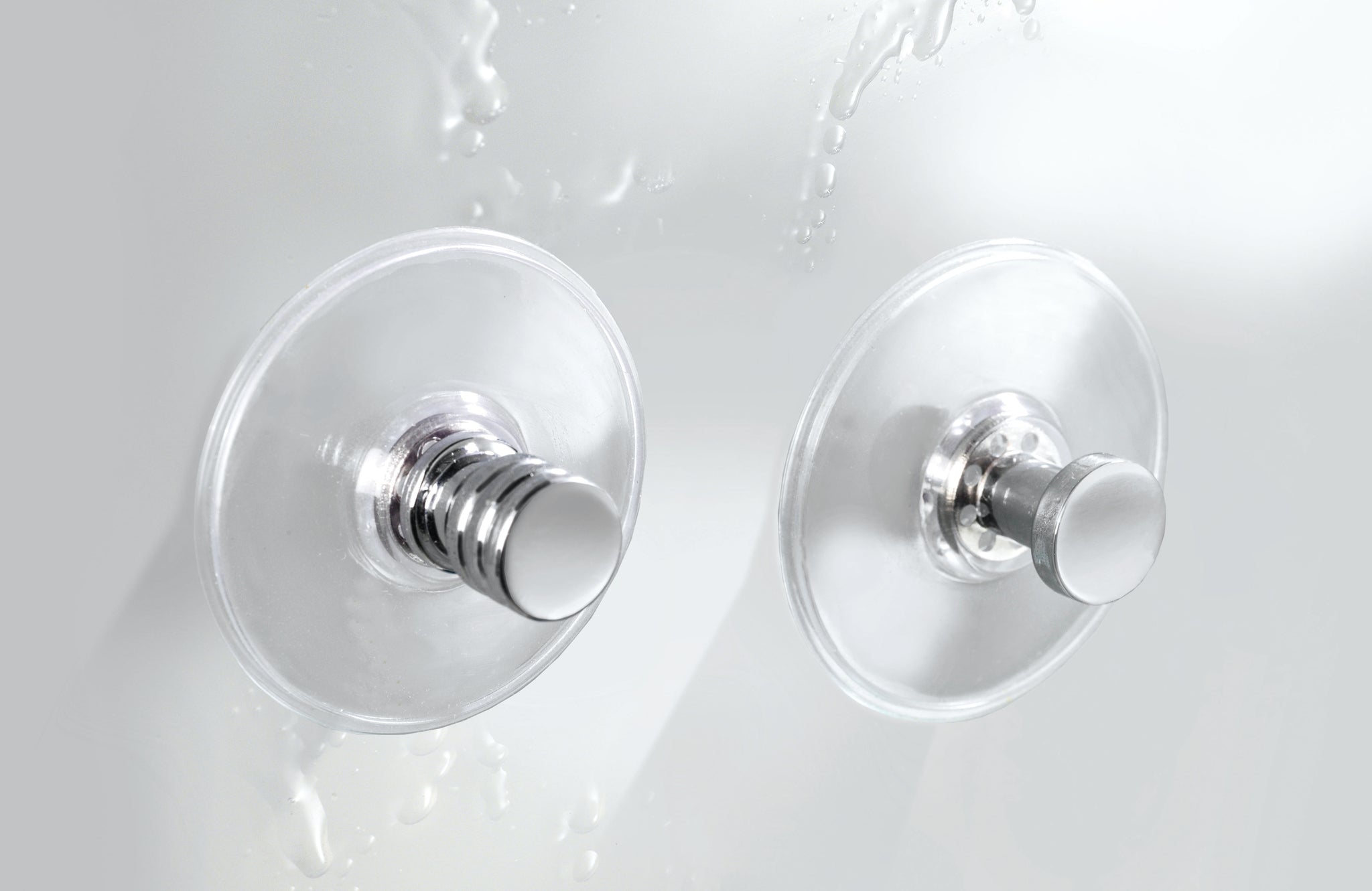 Zwei runde Chrom-Wandhaken mit transparenten Saugnäpfen im Bad an Fliese