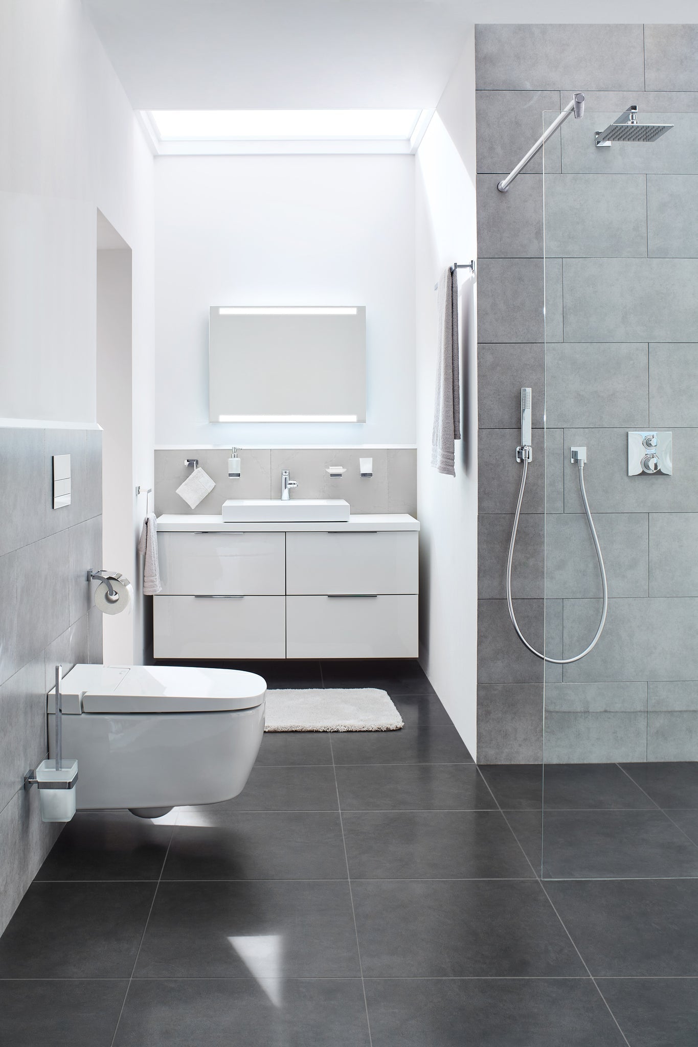 Modernes Bad mit wandhängendem WC, bodenebener Dusche und Waschtisch