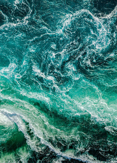 Türkisblaues, schäumendes Meer mit wilden Wellen.