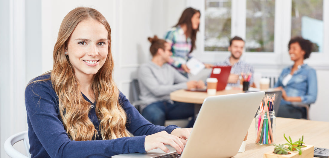Junge Frau am Laptop im Büro für Kleine Wolke Karriere Ausbildung.