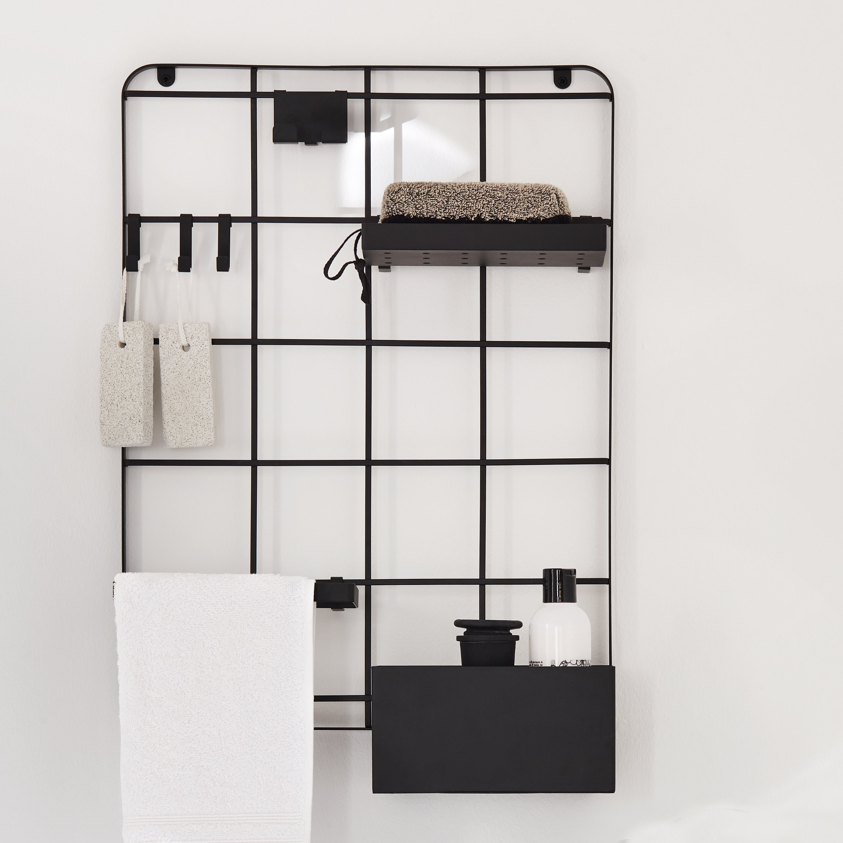 Schwarzes Kleine Wolke Wandregal mit Badzubehör wie Handtuch, Schwamm, Spender und Haken.