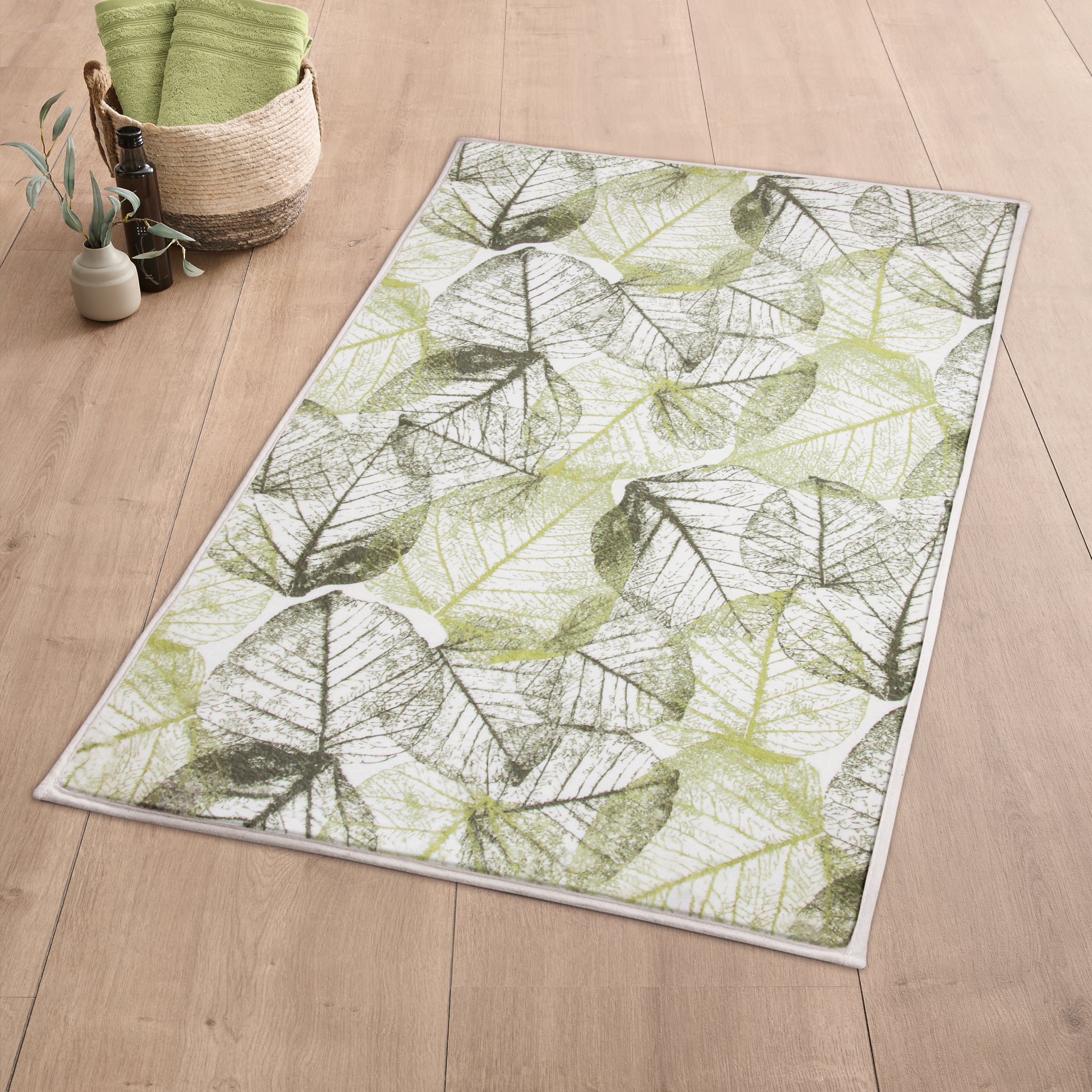 Kleine Wolke Badteppich mit grünem Blätter-Motiv auf Holzfußboden liegt im Badezimmer.