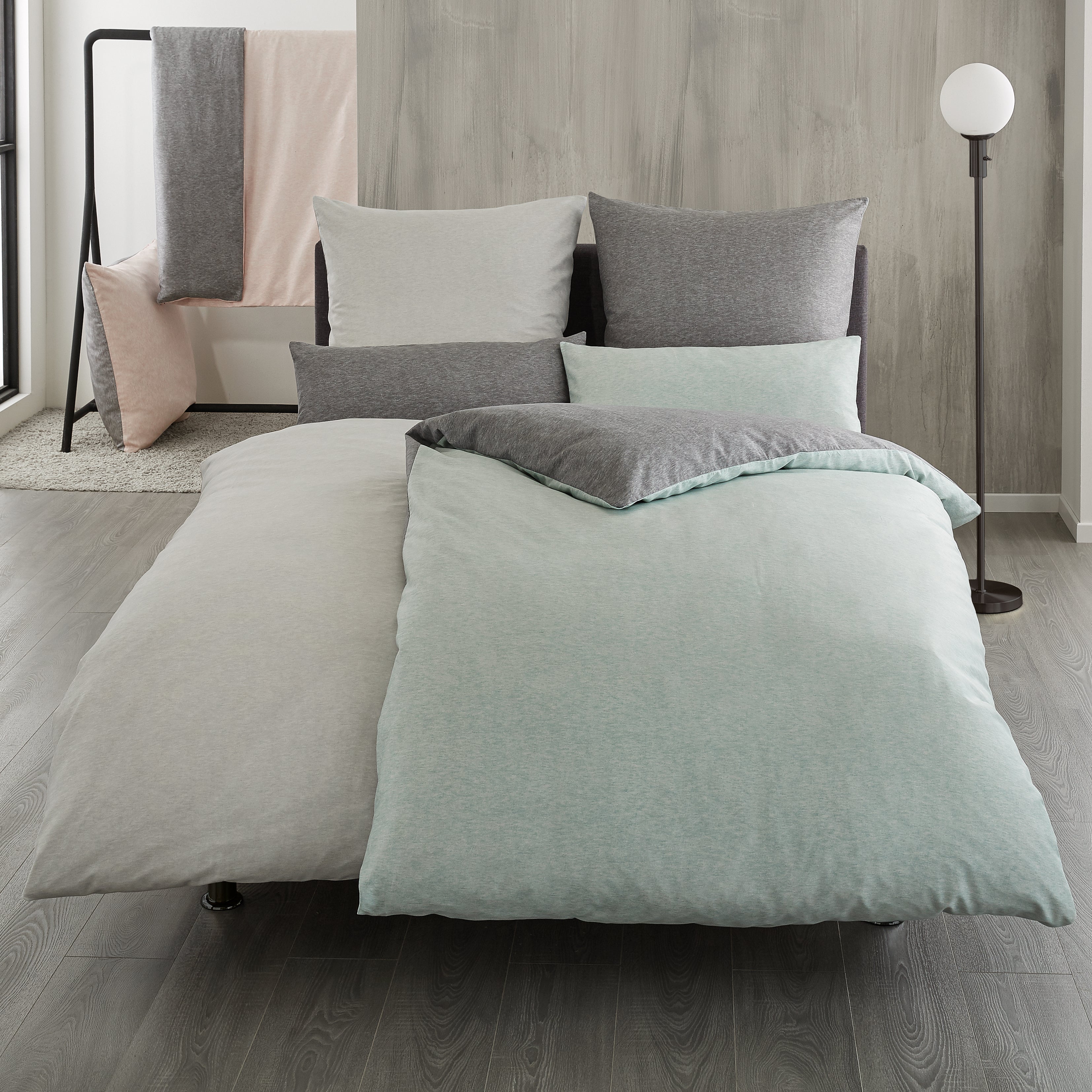 Uni Bettwäsche Kleine Wolke in Grau und Mint ist auf einem modernen Bett arrangiert.
