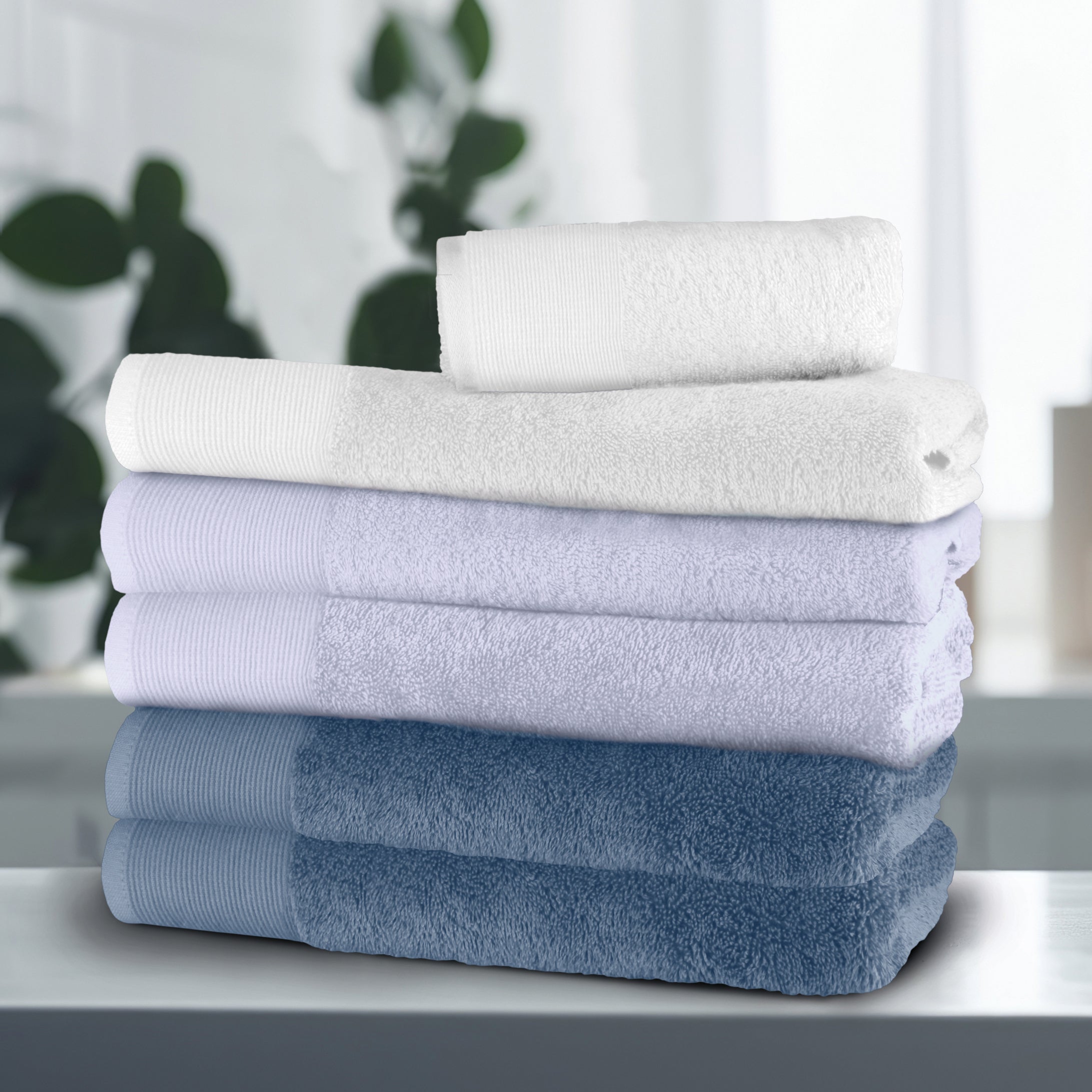 Gestapelte Kleine Wolke Gästehandtücher in Weiß, Helllila und Blau im modernen Bad.