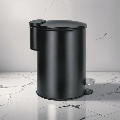 Schwarzer Kosmetikeimer steht auf hellem Marmorfußboden vor grauer Wand.