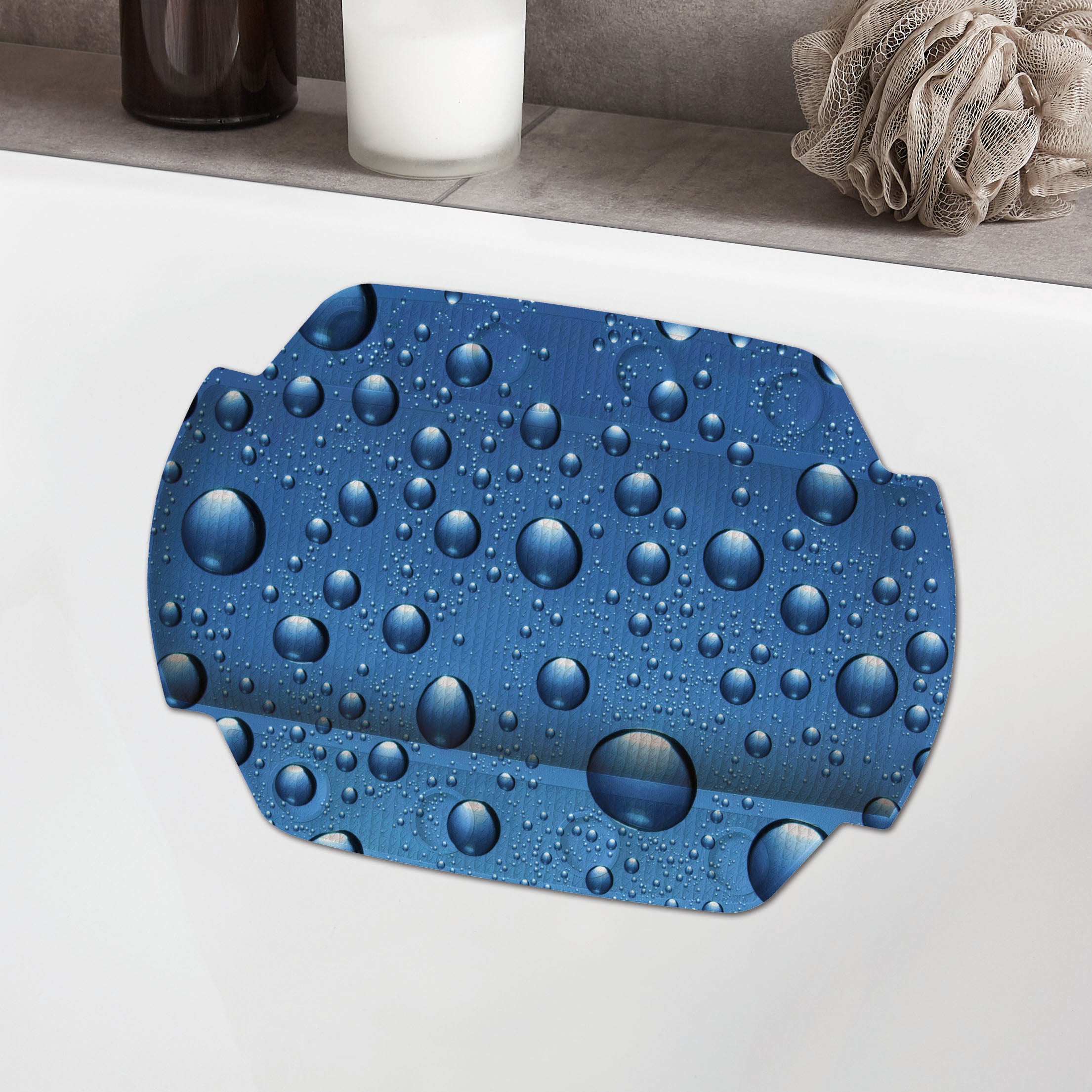 Blaues Nackenpolster mit Wassertropfen-Design liegt auf dem Wannenrand im modernen Bad.