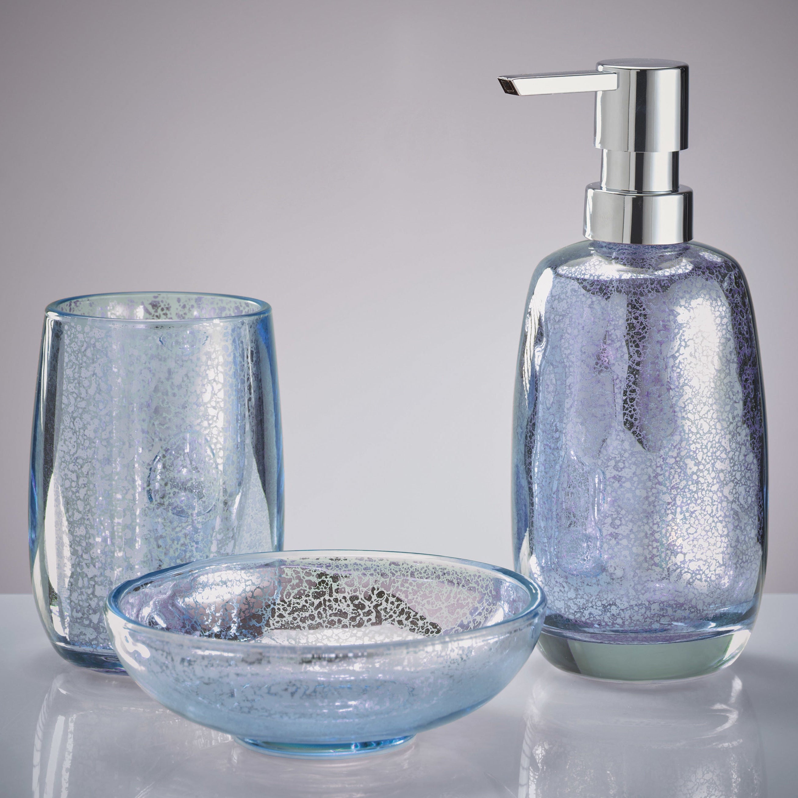 Glänzende blaue Bad-Accessoires von Kleine Wolke mit Spender, Becher und Schale stehen zusammen.