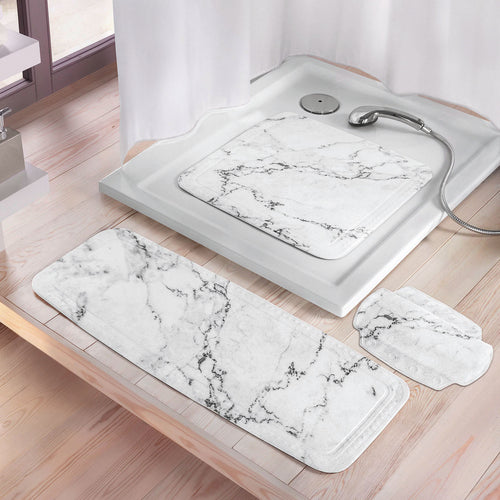 Marmorierte Kleine Wolke Sicherheitseinlagen liegen in Dusche und davor auf hellen Fliesen.