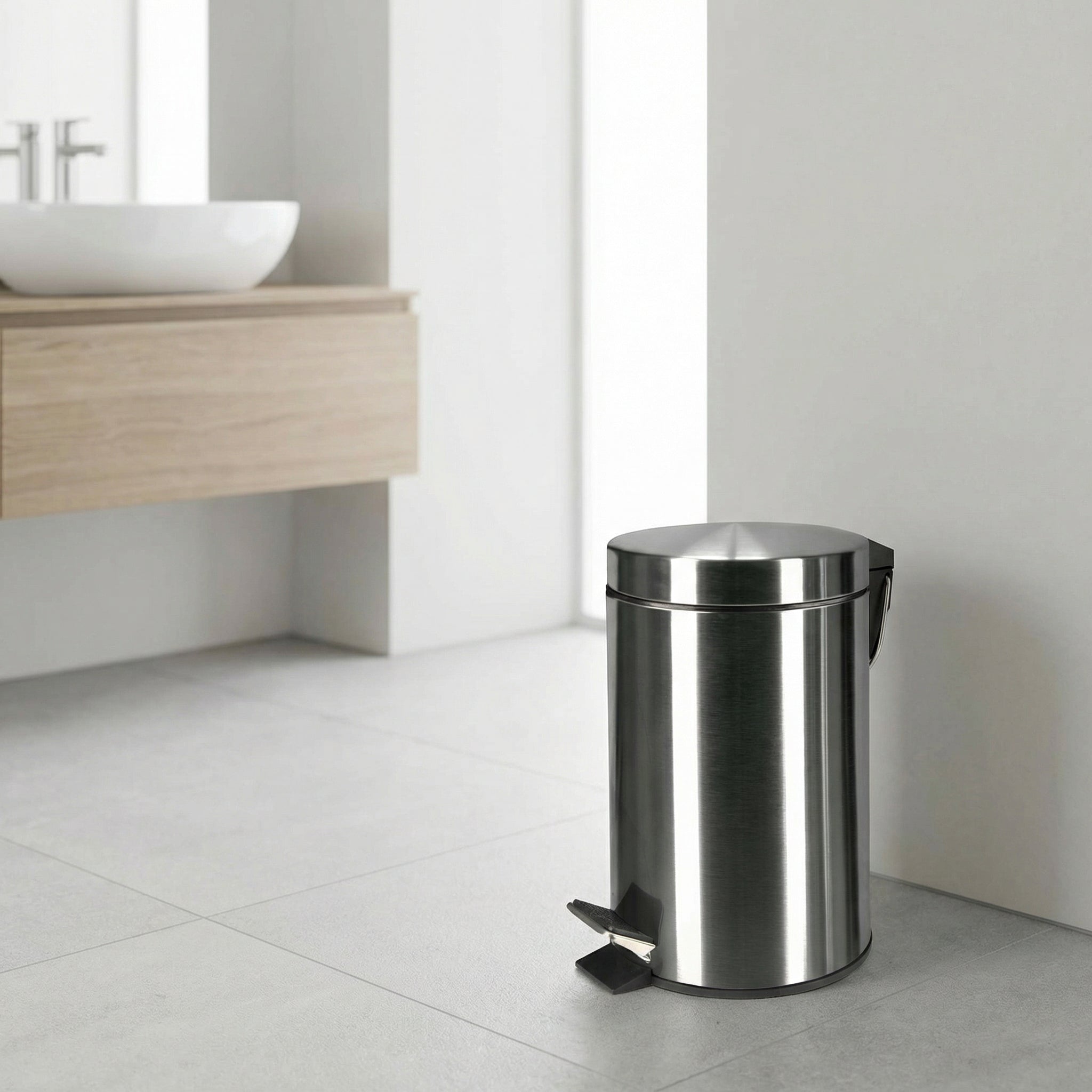 Runder Tretmülleimer aus Edelstahl in modernem, hellen Badezimmer