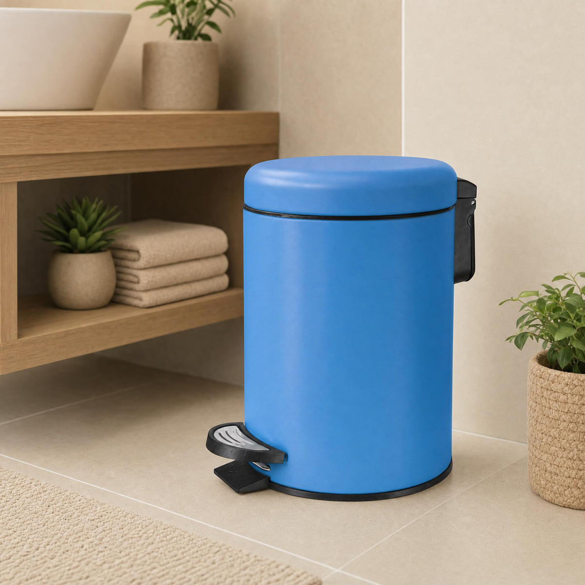 Blauer Treteimer im Badezimmer neben Holzregal mit Handtüchern und Pflanzen.