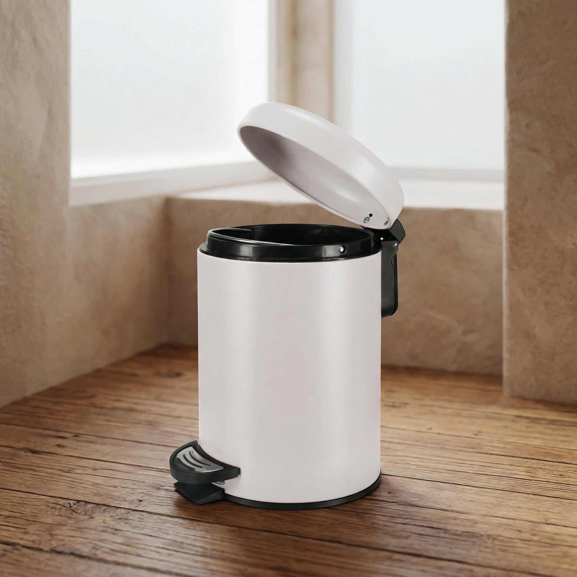 Weißer runder Tretmülleimer mit offenem Deckel auf Holzboden im Bad
