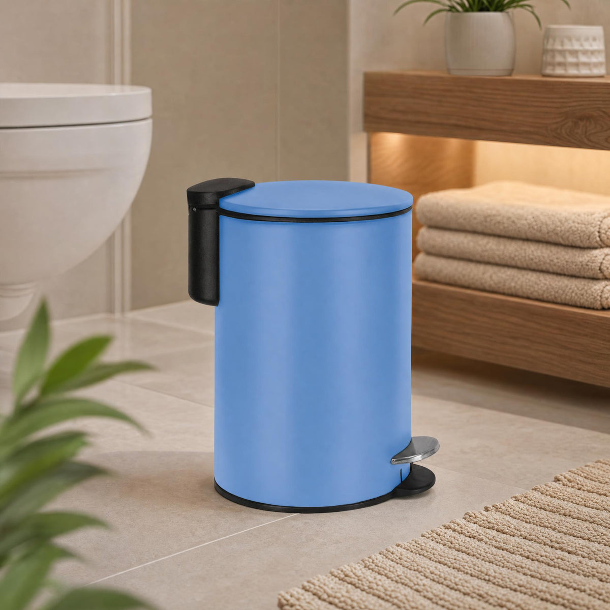 Blauer Treteimer im modernen Badezimmer neben WC und Holzregal.