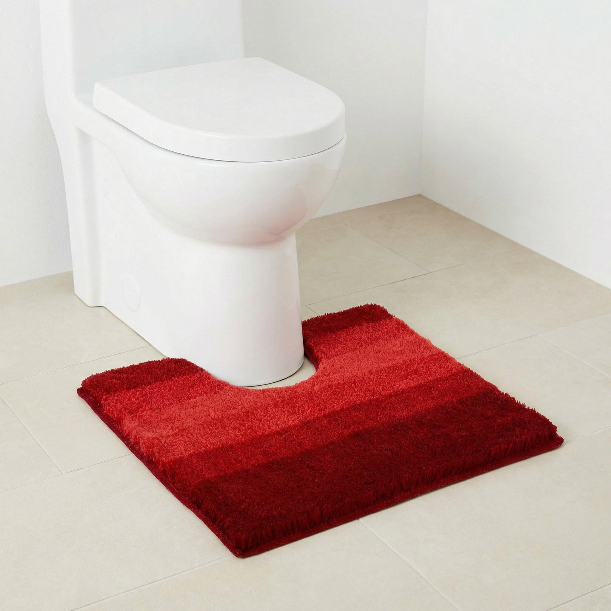 Weiße Toilette mit rot gestreifter Badematte auf hellen Bodenfliesen