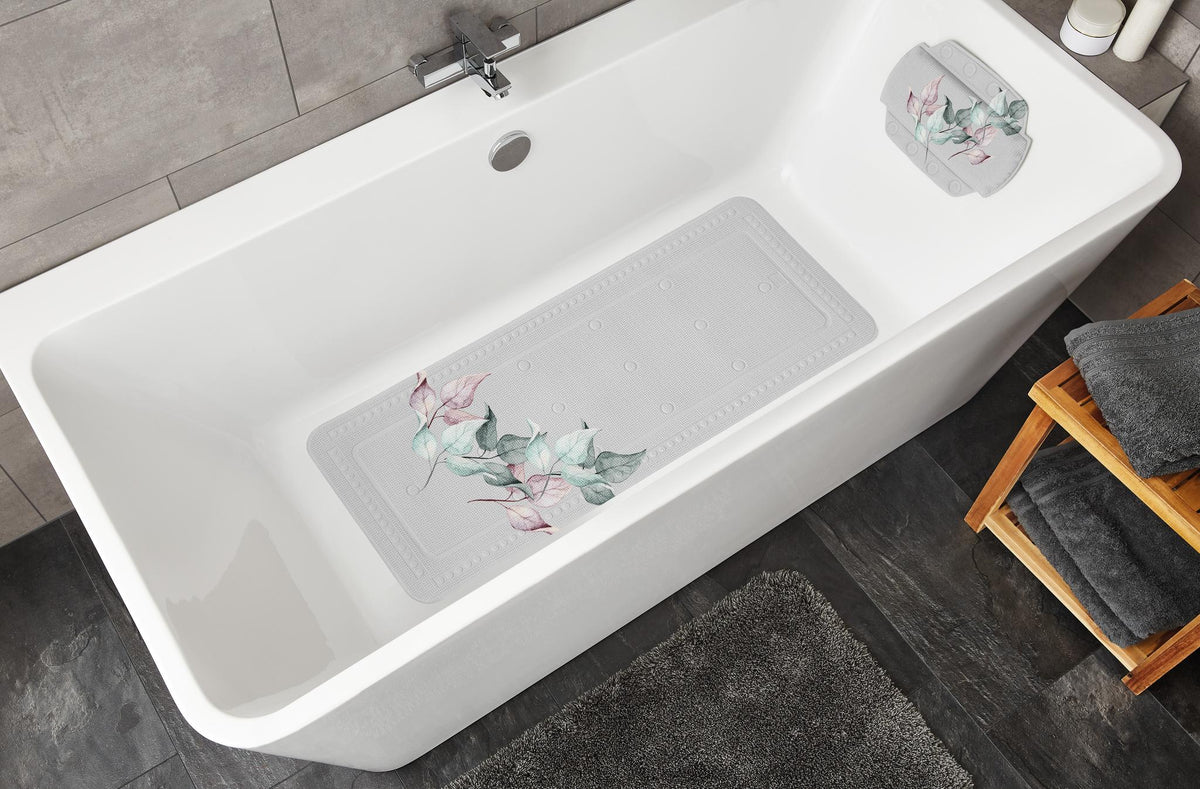 Weiße Badewanne mit floralem Wannenkissen und passender Antirutschmatte.