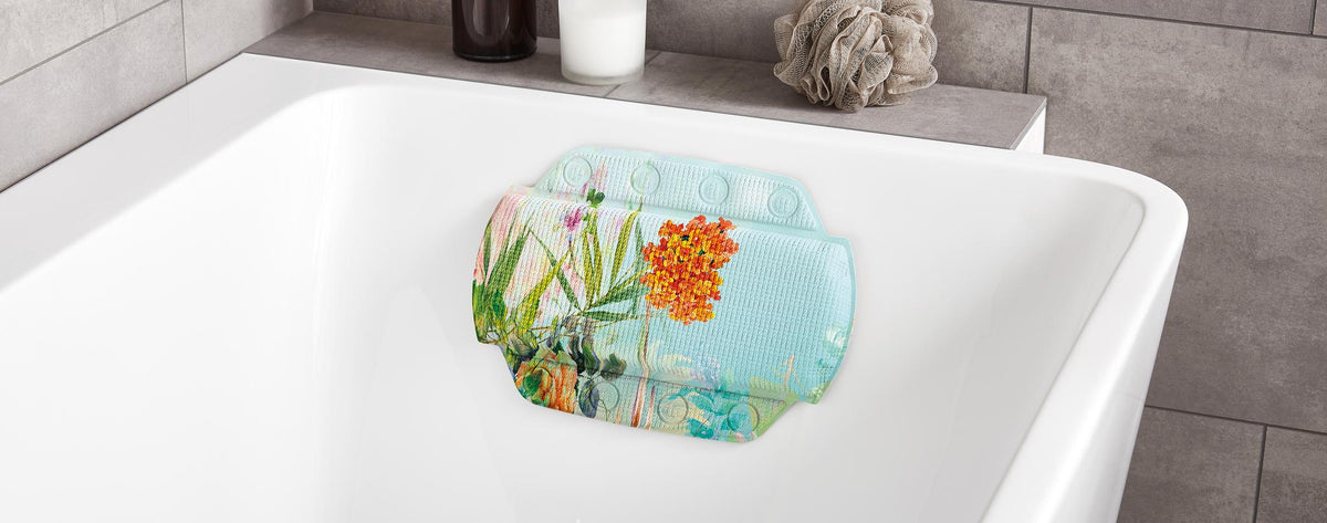 Nackenpolster mit Blumenmuster liegt in einer weißen Badewanne.