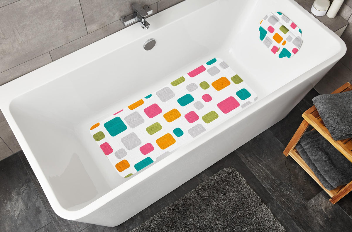 Badewanne mit bunter Antirutschmatte und passendem Kissen im Bad.