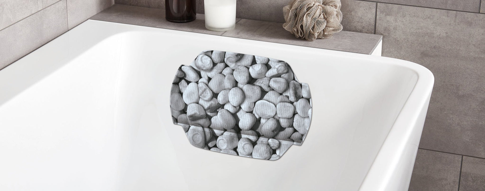 Nackenpolster STEPSTONE Grau 32x22 cm mit Steinmotiv an weißer Badewanne im modernen Bad.
