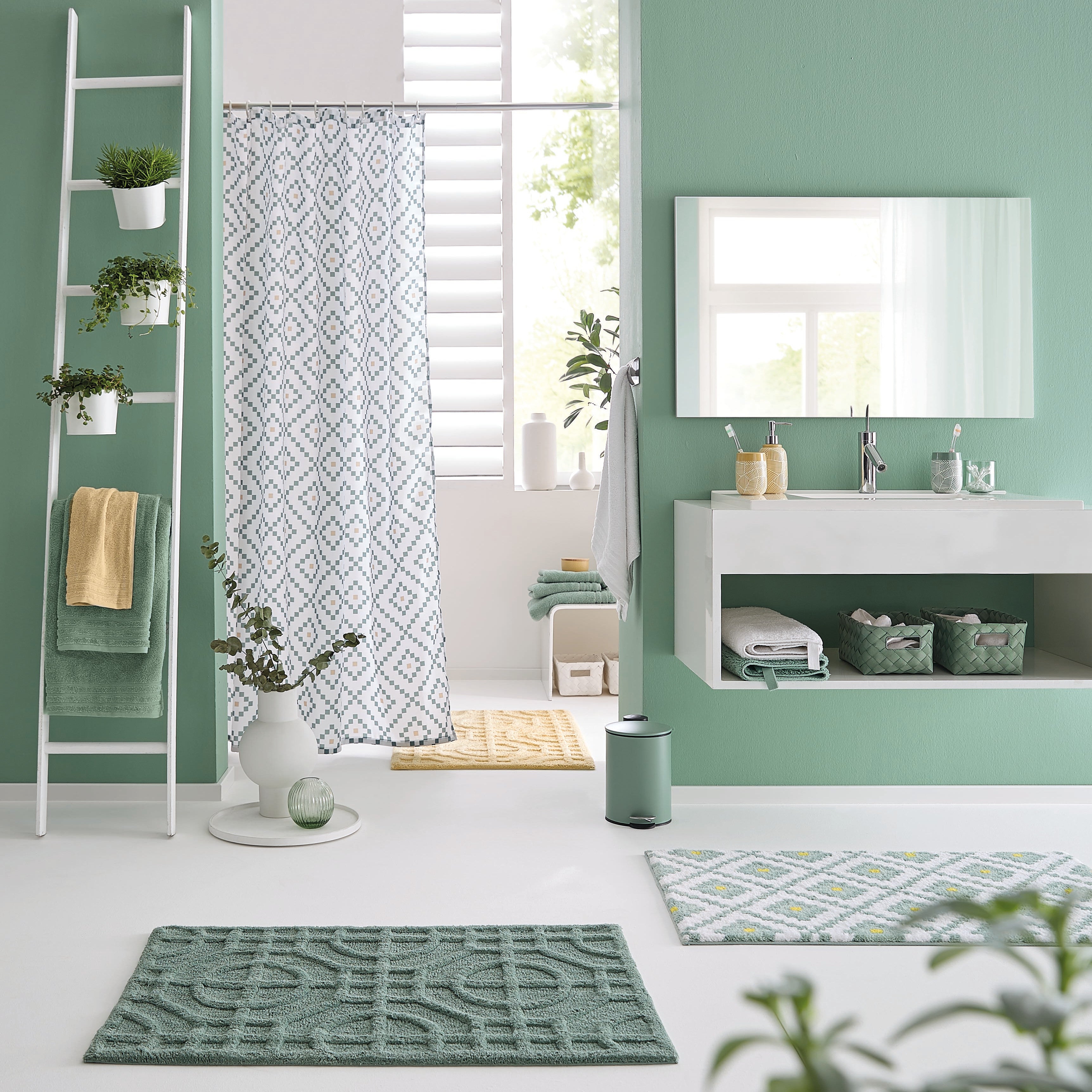 Badezimmer mit grünen Kleine Wolke Badteppichen und Duschvorhang mit geometrischem Muster.