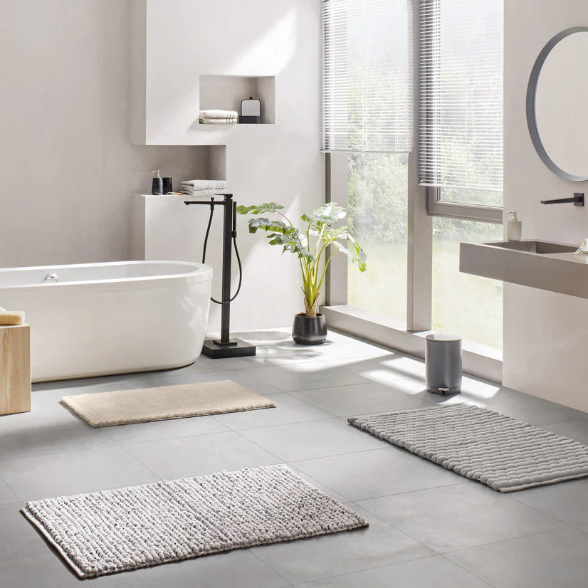 Kleine Wolke Signature Collection Badematten in modernem Badezimmer mit Badewanne und Pflanzen.