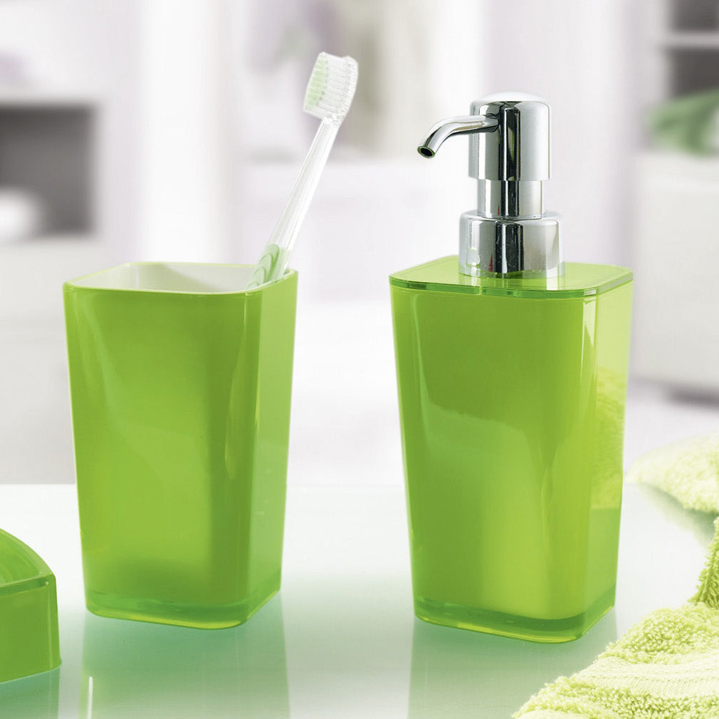 Grüner Zahnputzbecher mit Zahnbürste und passendem Seifenspender steht im modernen Bad.