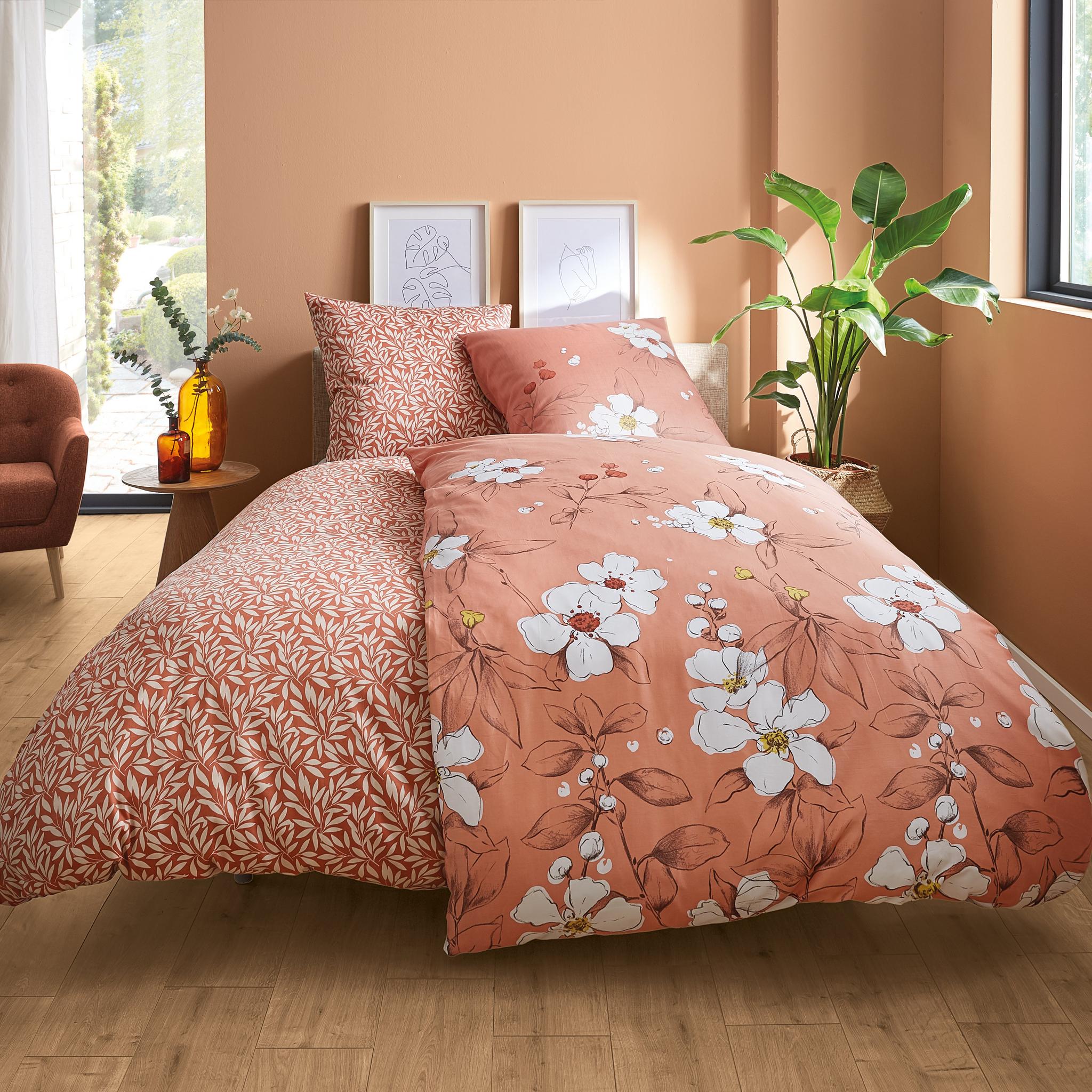 Terrakottafarbene Bettwäsche mit Blumenmuster in modernem Schlafzimmer