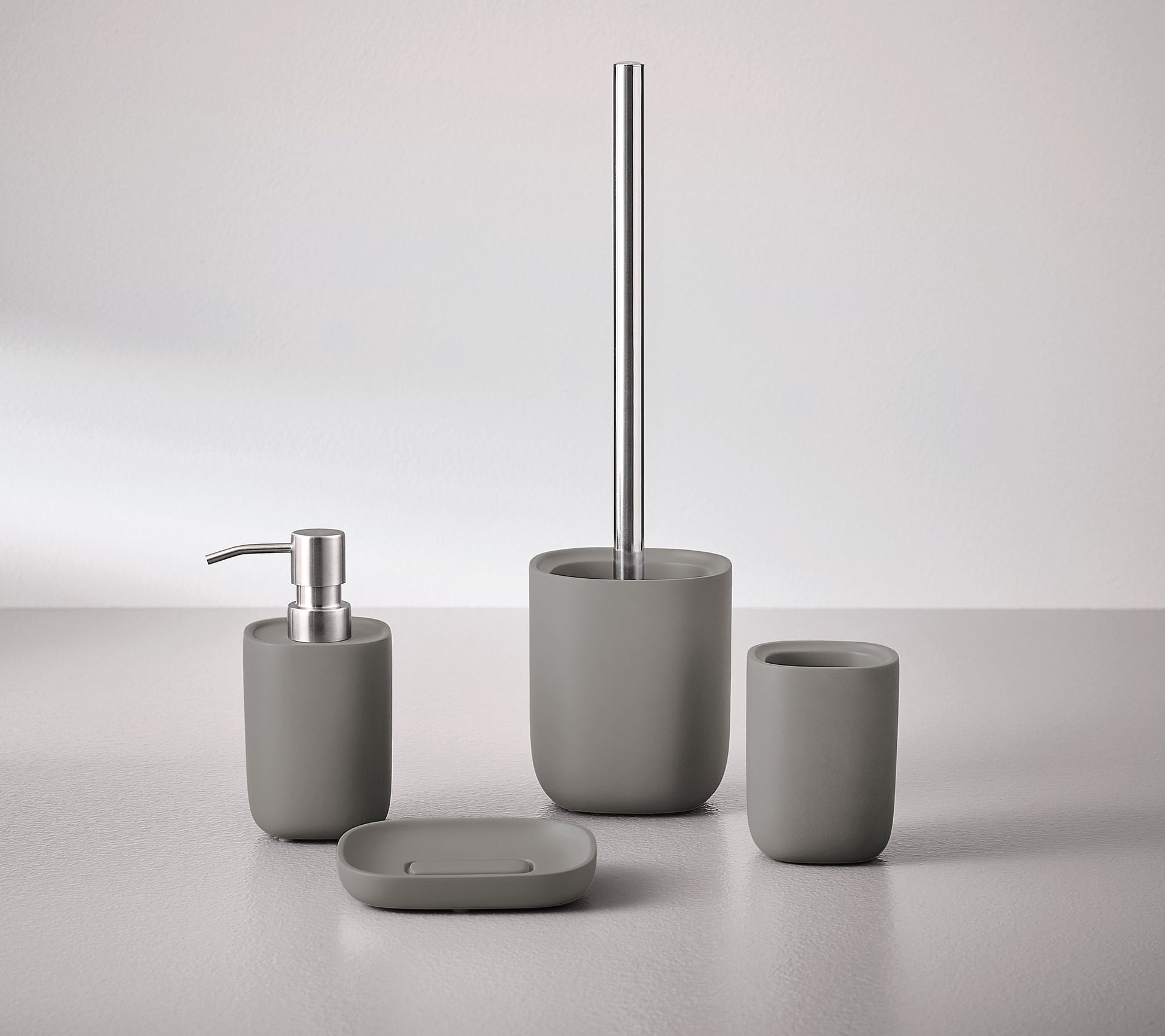 Seifenschale ALITA Schiefer steht mit passendem Bad-Set aus Spender, Becher und WC-Bürste auf hellem Tisch.